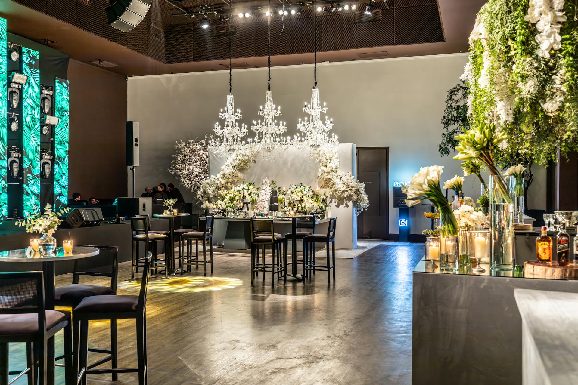 A spacious function venue with elegantly arranged tables, chairs, and white floral decor, perfect for weddings and events.