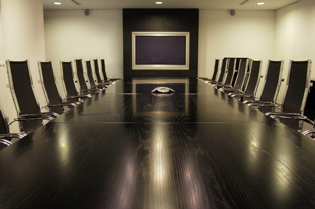 A modern conference room with a large table and chairs, designed for executive meetings and business discussions.
