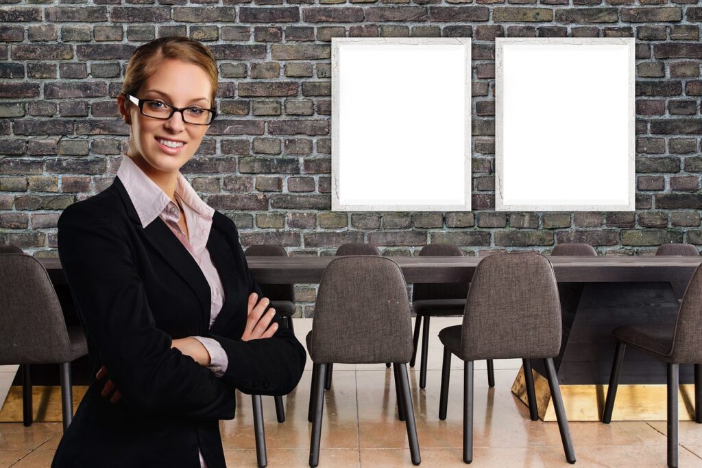 A professional business setting with office chairs, tables, whiteboards, and a speaker standing before a brick wall, ideal for team meetings and corporate training sessions.