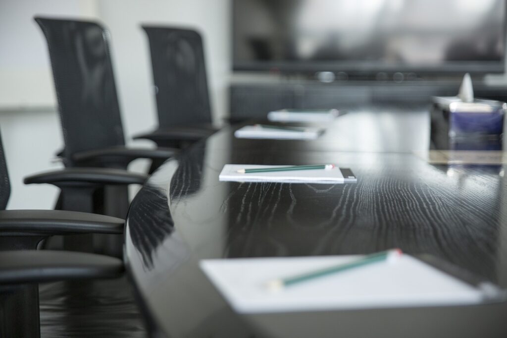 A close-up view of a table with papers and pencils in a professional meeting room, ideal for business discussions and brainstorming.