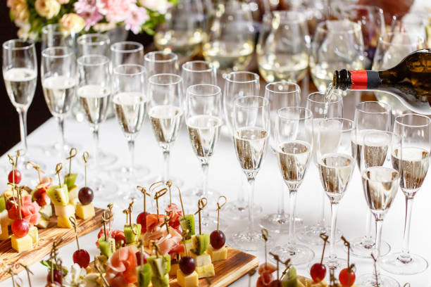 A beautifully arranged wedding reception table filled with champagne glasses and gourmet food at a luxurious wedding venue.